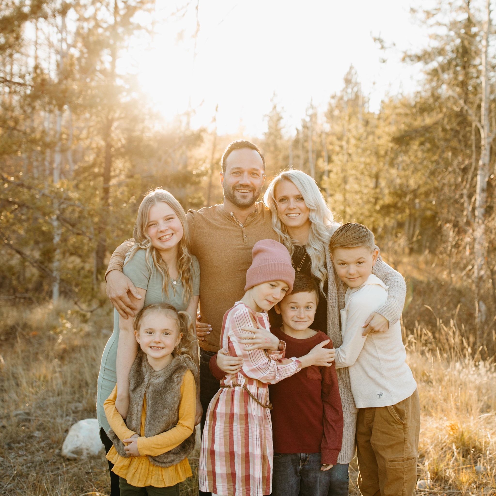 The family behind Hand and Hammer, a local contracting business in Cranbrook, BC, smiling together outdoors.