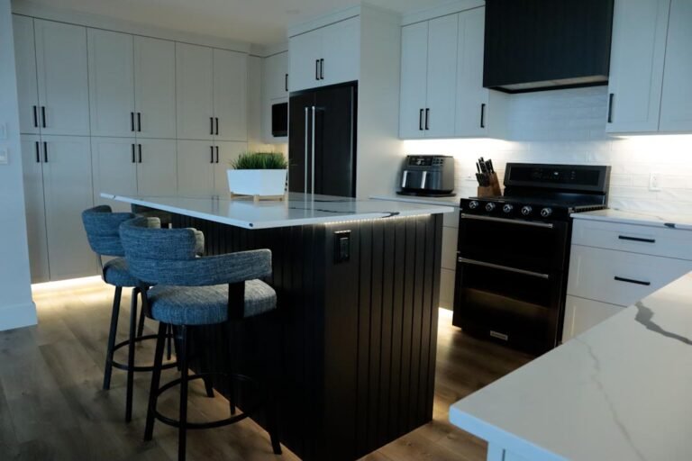Custom black fluted kitchen island with white marble-veined quartz countertop and LED under-counter accent lighting in a Cranbrook renovation by Hand and Hammer.